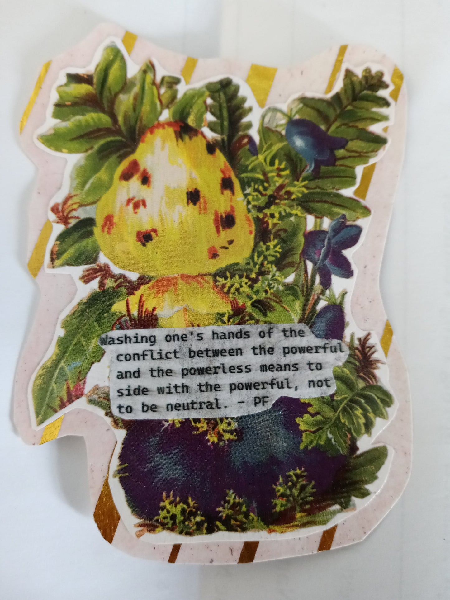 A handmade sticker of an irregular shape with a white and gold foil edging surrounding a Victorian style floral arrangement in blue yellow and green with a quote on white paper over top that reads "Washing one's hands of the conflict between the powerful and the powerless means to side with the powerful, not to be neutral. - PF"